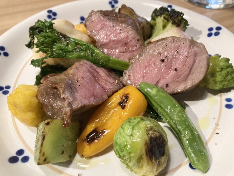 シチリア料理アガタ ランチコース2品目:ポークと野菜のグリル。豚肉、芽キャベツ、パプリカ、カリフラワー、ロマネスコ、えびいも、ブロッコリーの写真